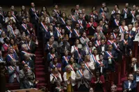 Members of the National Assembly stand and applaud to pay homage to children victims of a knife attack in a town the French Alps, Thursday, June 8, 2023 in Paris. France's interior minister Gerald Darmanin says Thursday June 8, 2023 that an attacker with a knife injured children and others in a town in Annecy, French Alps. In a short tweet, he said police have detained the attacker (AP Photo/Lewis Joly)