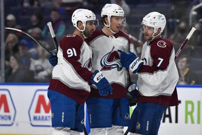 Colorado Avalanche center Nazem Kadri, left, celebrates with left wing Andre Burakovsky, center and defenseman Devon Toews after scoring against the Buffalo Sabres during the first period of an NHL hockey game in Buffalo, N.Y., Saturday, Feb. 19, 2022. (AP Photo/Adrian Kraus)