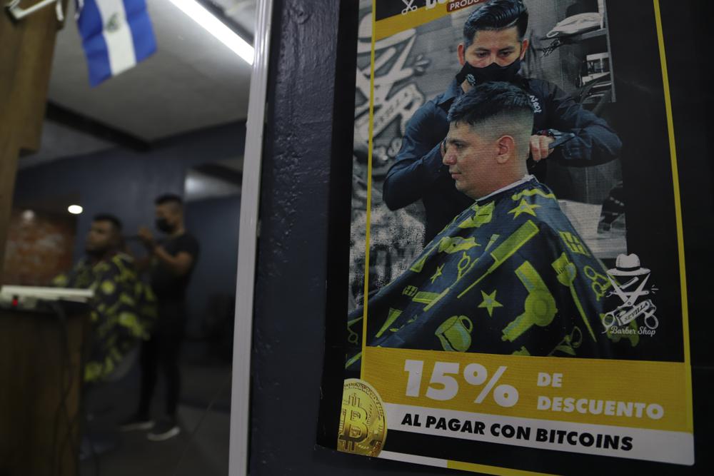 Un cartel dentro de una barbería anuncia descuentos para quienes paguen con la criptomoneda Bitcoin en Santa Tecla, El Salvador, el sábado 4 de septiembre de 2021. (AP Foto/Salvador Meléndez)