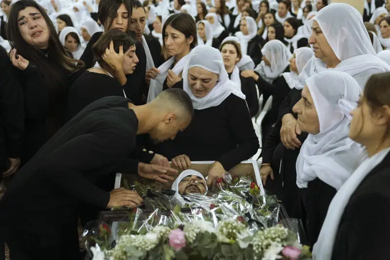 FILE - Members of the Israeli Druze minority mourn around the body of Tiran Fero, 17, during his funeral in Daliyat al-Carmel, Israel, on Nov. 24, 2022. Israel’s military says its prosecutor has filed indictments against two soldiers who allegedly hurled an explosive device at a Palestinian home in the occupied West Bank last month. The indictment announced Thursday, Dec. 29, said the two soldiers acted out of revenge for the kidnapping of the body of an Israeli schoolboy in the flashpoint West Bank city of Jenin on Nov. 22. (AP Photo/Mahmoud Illean, File)