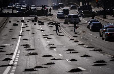 Vehículos se detienen ante un bloqueo establecido por elementos de defensa civil, el lunes 28 de febrero de 2022, en una avenida que va al centro de Kiev, Ucrania. (AP Foto/Emilio Morenatti)
