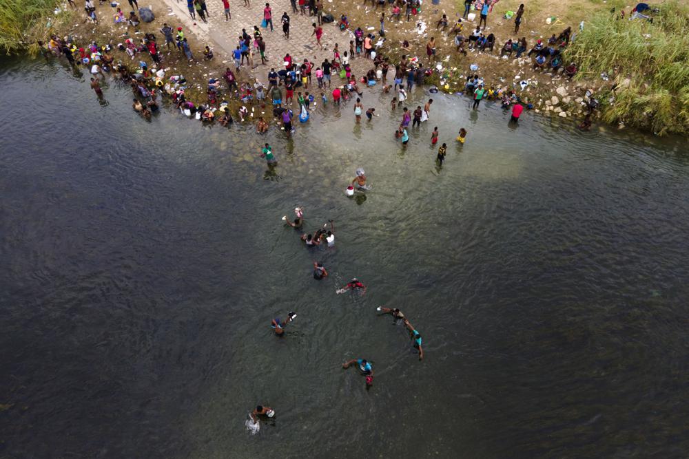 Migrantes, muchos de ellos de Haití, vadean el Rio Grande entre Estados Unidos y México el martes, 21 de septiembre del 2021. (AP Foto/Julio Cortez)