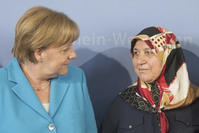 ARCHIVO - La canciller alemana Angela Merkel (izquierda) platica con Mevlude Genc, madre, abuela y tía de víctimas de un atentado, en Düsseldorf, Alemania, el martes 29 de mayo de 2018. (Rolf Vennenbernd/dpa via AP, Archivo)