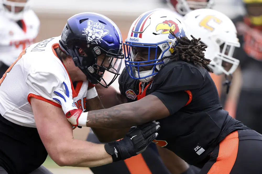 National offensive lineman Blake Freeland of BYU (73) and National defensive lineman Lonnie Phelps Jr of Kansas (9) run drills during practice for the Senior Bowl NCAA college football game Thursday, Feb. 2, 2023, in Mobile, Ala.. (AP Photo/Butch Dill)