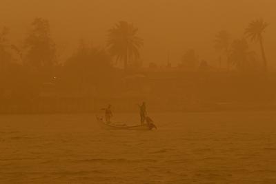 Los pescadores navegan en la vía fluvial Shatt al-Arab durante una tormenta de arena en Basora, Irak, el lunes 23 de mayo de 2022. (AP Foto/Nabil al-Jurani)
