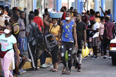 ARCHIVO - Haitianos, muchos de los cuales han estado esperando hasta un año en México para que se procesen sus solicitudes de asilo, hacen fila para recibir remesas de familiares frente a la tienda Salinas y Rocha, el 3 de septiembre de 2021, en Tapachula, México. (AP Foto/Marco Ugarte, archivo)