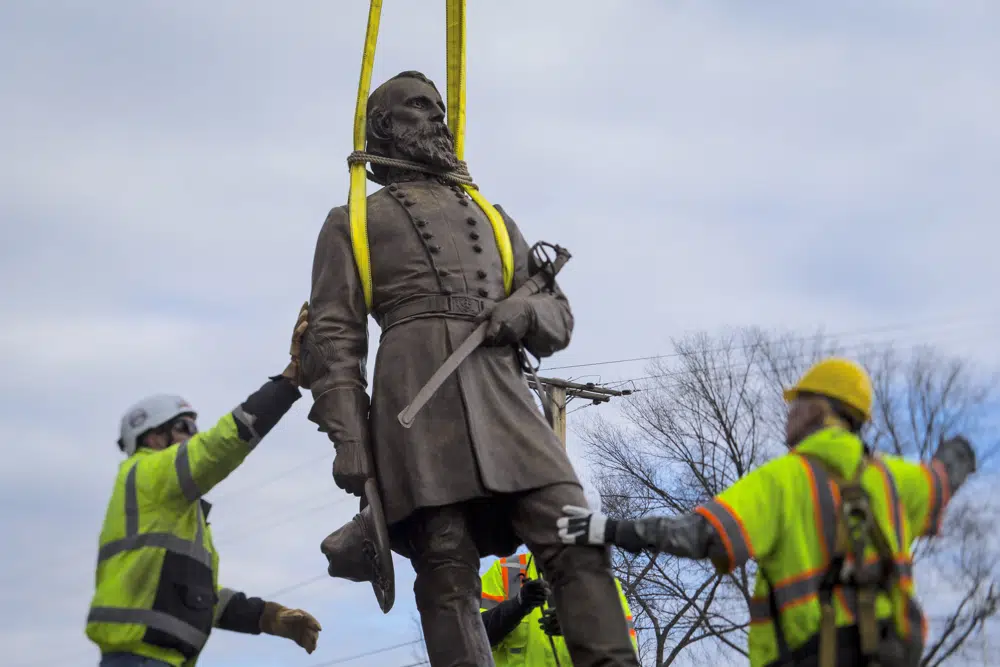 Workers begin to lay the bronze statue of Confederate General A.P. Hill onto a flatbed truck on Monday Dec. 12, 2022 in Richmond, Va. Workers are still planning to exhume the remains of General Hill which located inside the base of the statue. (AP Photo/John C. Clark)