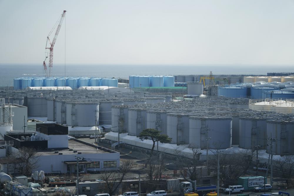 Tanks storing treated radioactive water after it was used to cool the melted fuel are seen at the Fukushima Daiichi nuclear power plant, run by Tokyo Electric Power Company Holdings (TEPCO), in Okuma town, northeastern Japan, Thursday, March 3, 2022. The government has announced plans to release the water after treatment and dilution to well below the legally releasable levels through a planned undersea tunnel at a site about 1 kilometer offshore.  (AP Photo/Hiro Komae)