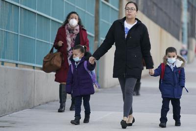 Una mujer con niños llega a una escuela en Nueva York, el 7 de marzo de 2022. (AP Foto/Seth Wenig, File)
