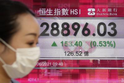 Una persona frente a una cartelera financiera en Hong Kong el 10 de junio de 2021.  (Foto AP/Kin Cheung)