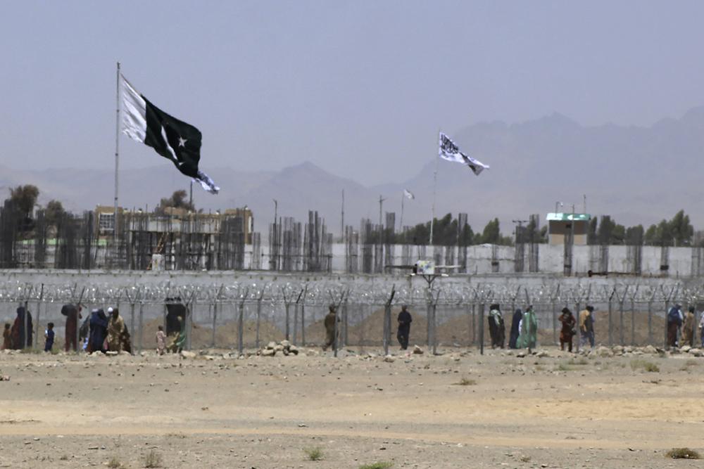Stranded people cross the border between Pakistan and Afghanistan, in Chaman, Pakistan, Friday, Aug. 13, 2021. Pakistan opened its Chaman border crossing for people who had been stranded in recent weeks. Juma Khan, the Pakistan border town's deputy commissioner, said the crossing was reopened following talks with the Taliban. (AP Photo/Jafar Khan)
