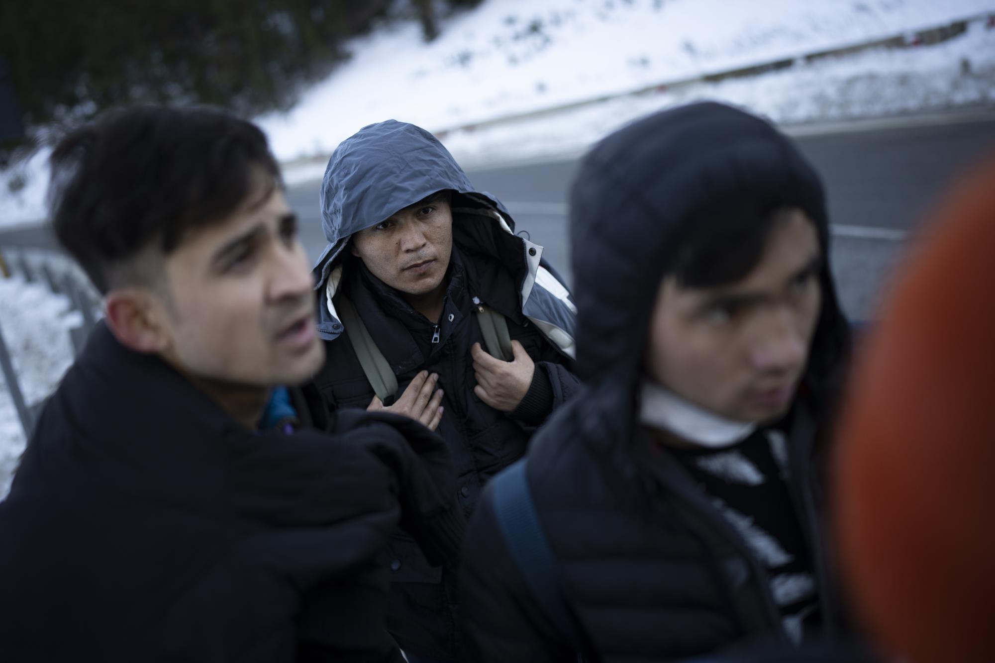 Afghan migrants headed to France from Italy walk along a mountain road leading to the French-Italian border, Wednesday, Dec. 15, 2021. When the Taliban seized power in Afghanistan in August, some Afghans resolved to escape and embarked on forbidding journeys of thousands of kilometers to Europe. (AP Photo/Daniel Cole)