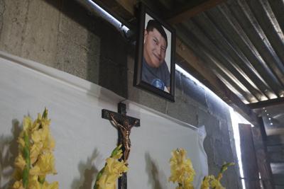 Un retrato del migrante guatemalteco Daniel Arnulfo Pérez Uxla, de 41 años, cuelga sobre sus restos durante su funeral, el domingo 19 de diciembre de 2021, en El Tejar, Guatemala. (AP Foto/Moises Castillo)