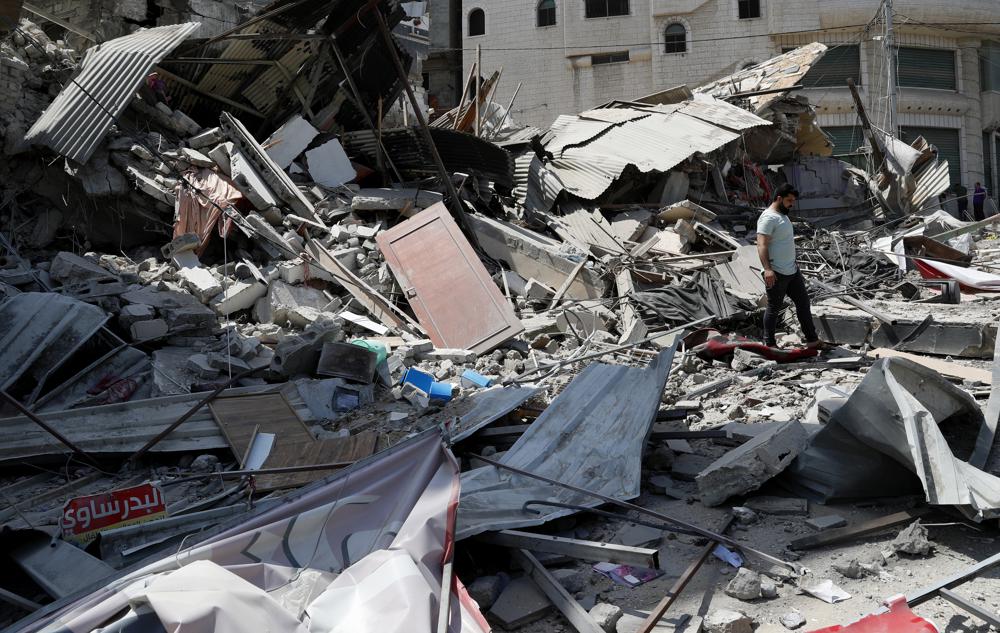 Un hombre inspecciona los escombros de un edificio residencial destruido que fue alcanzado por ataques aéreos israelíes, en la ciudad de Gaza, el jueves 20 de mayo de 2021 (AP Photo / Adel Hana).