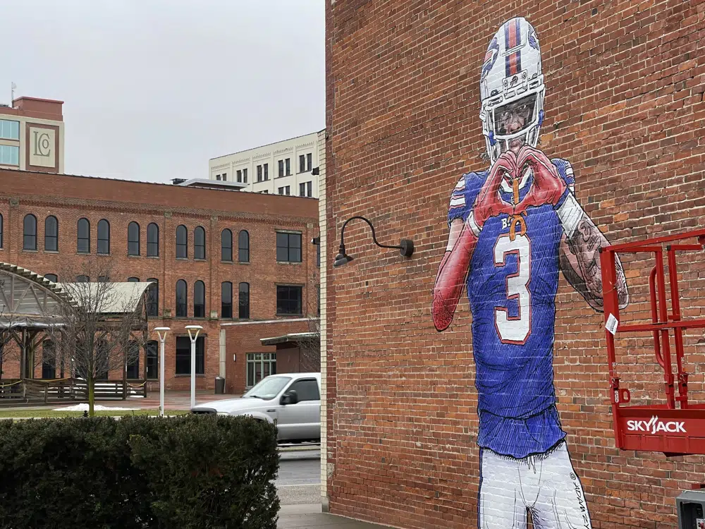 A mural by artist Adam Zyglis of Buffalo Bills player Damar Hamlin, who is recovering after going into cardiac arrest during a game Jan. 2, covers the outside of a building in Buffalo, N.Y., on Wednesday, Jan. 18, 2023. (AP Photo/Carolyn Thompson)