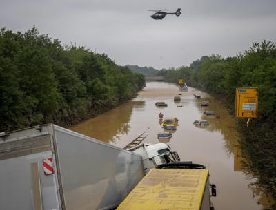 El retroceso del agua deja a la vista los techos de los autos varados en una carretera anegada, en Erftstadt, Alemania, el 17 de julio de 2021. (AP Foto/Michael Probst)