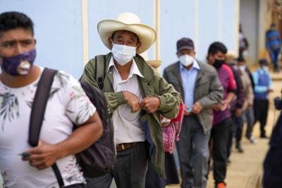 Los votantes hacen fila en un colegio electoral en Tacabamba, Perú, el domingo 6 de junio de 2021. Los peruanos votan el domingo en una segunda vuelta presidencial para elegir entre Pedro Castillo, un novato político que hasta hace poco era maestro de escuela rural, y Keiko Fujimori, la hija del expresidente encarcelado Alberto Fujimori. (Foto AP/Martín Mejía)