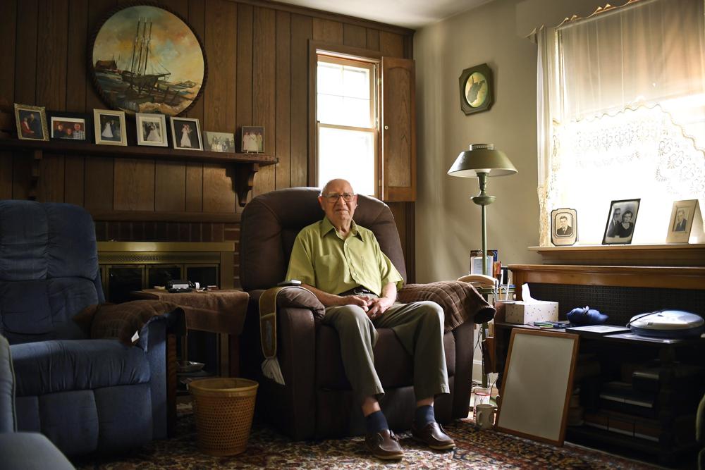 In this Saturday, July 17, 2021, photo, Fred Ware sits in his living room in Manchester, Conn. Ware and his son Dave recently found a whites-only covenant on his property dating back to 1942 when researching the title chain. Upon finding the covenant, Dave Ware, who grew up in the home, reached out to state lawmakers and helped get a bill passed that strips these covenants on properties. (AP Photo/Jessica Hill)