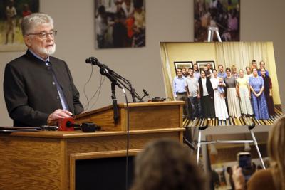 Una fotografía grupal de 17 personas que fueron secuestradas en Haití es exhibida mientras el director general de la agencia Christian Aid Ministries, David Yoder, habla durante una conferencia de prensa en Berlin, Ohio, el lunes 20 de diciembre de 2021. (AP Foto/Tom E. Puskar)