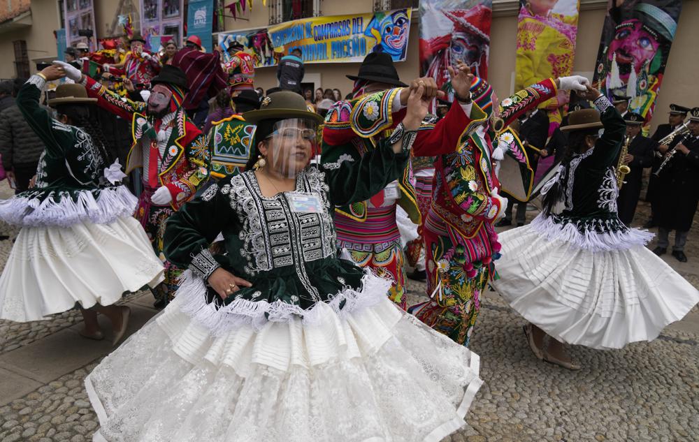 Los bailarines usan protectores faciales para frenar la propagación del nuevo coronavirus mientras actúan durante la inauguración de las celebraciones del Carnaval en medio de la pandemia de COVID-19, en La Paz, Bolivia, el domingo 6 de febrero de 2022. (AP Foto/Juan Karita)