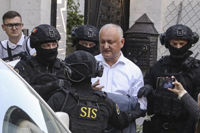 Miembros del Servicio de Información y Seguridad de Moldavia (SIS) escoltan al ex presidente moldavo Igor Dodon a una camioneta después de que fue detenido en su casa en Chisinau, Moldavia, el martes 24 de mayo de 2022. Los medios moldavos informaron que la policía estaba llevando a cabo un registro de una casa descrita como perteneciente a Dodon, quien se desempeñó como presidente de 2016 a 2020. (AP Foto/Aurel Obreja)