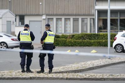 Agentes montan guardia en la escena de disparos en Nasby, un barrio de Kristianstad, Suecia, martes 3 de agosto de 2021. La policía dijo que al menos dos personas resultaron heridas. (Johan Nilsson/TT News Agency via AP)
