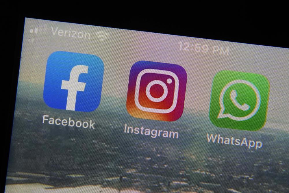 FILE - The mobile phone apps for, from left, Facebook, Instagram and WhatsApp are shown on a device in New York. The company that owns Facebook and Instagram said Monday, May 23, 2022, it will begin revealing more details about how advertisers target people with certain political ads, just months before the U.S. Midterm elections. (AP Photo/Richard Drew, File)