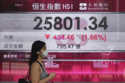 Una persona frente a una cartelera financiera en hong kong el 3 de agosto del 2021.  (AP Photo/Vincent Yu)