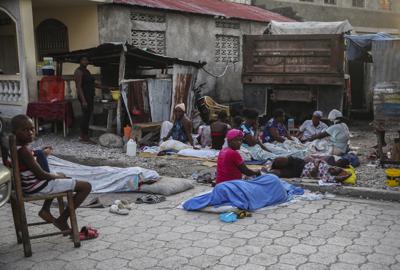 Un grupo de personas empiezan a despertar el domingo 15 de agosto de 2021 luego de pasar la noche en la calle tras un sismo de magnitud 7,2 en Los Cayos, Haití. (AP Foto/Joseph Odelyn)