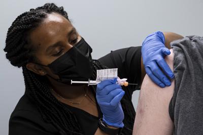 En esta imagen del miércoles 31 de marzo de 2021, Cole Smith recibe la vacuna contra el COVID-19 de Moderna de parte de la enfermera Tigisty Girmay, en la Clínica Hope de la Universidad Emory, en Decatur, Georgia. (AP Foto/Ben Gray, Archivo)