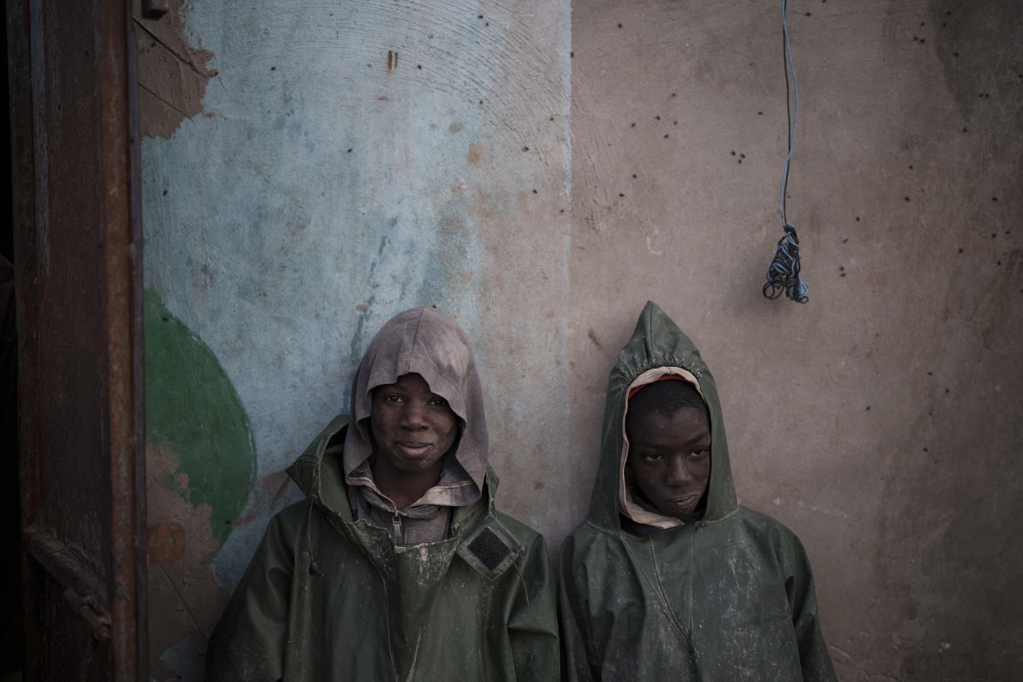 Dos jóvenes pescadores de Senegal se apoyan contra una pared tras una expedición de pesca en Nuadibú, Mauritania, el 1 de diciembre de 2021. (AP Foto/Felipe Dana)