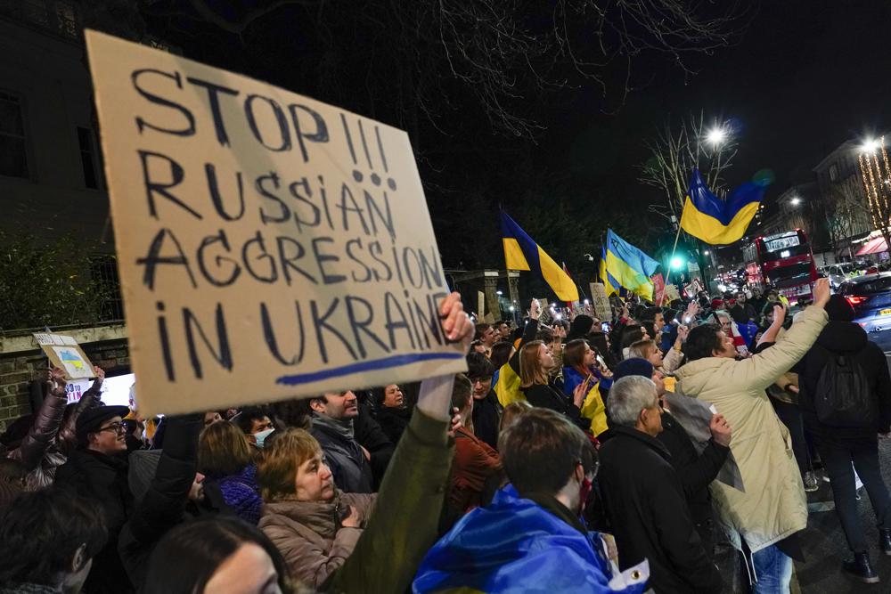 Manifestantes sostienen pancartas y banderas durante una protesta frente a la embajada rusa en Londres contra las acciones de Rusia en Ucrania, el miércoles 23 de febrero de 2022. (Foto AP/Alberto Pezzali)