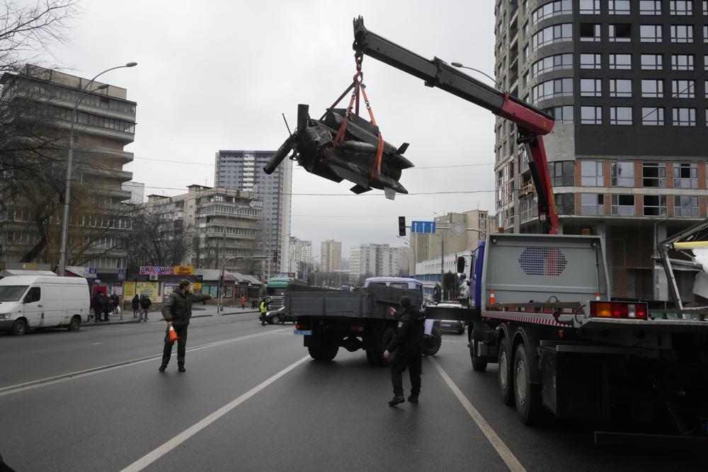 Workers load the debris of a rocket onto a truck the aftermath of Russian shelling in Kyiv, Ukraine, Thursday, Feb. 24, 2022. Russian troops have launched their anticipated attack on Ukraine. Big explosions were heard before dawn in Kyiv, Kharkiv and Odesa as world leaders decried the start of an Russian invasion that could cause massive casualties and topple Ukraine's democratically elected government. (AP Photo/Efrem Lukatsky)