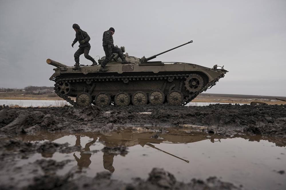 Ukrainian servicemen walk on an armored fighting vehicle during an exercise in a Joint Forces Operation controlled area in the Donetsk region, eastern Ukraine, Thursday, Feb. 10, 2022. A peace agreement for the separatist conflict in eastern Ukraine that has never quite ended is back in the spotlight amid a Russian military buildup near the country's borders and rising tensions about whether Moscow will invade.(AP Photo/Vadim Ghirda)