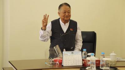 ARCHIVO _ En esta imagen tomada de un video, Win Htein hace la señal de protesta con los dedos el 2 de febrero del 2021 en Naypyitaw, Myanmar. Un tribunal en Myanmar declaró al colaborador cercano de la derrocada líder Aung San Kyi culpable de traición y lo sentenció a 20 años en prisión, dijeron un miembro de su partido y la prensa local el 29 de octubre. (AP Foto)