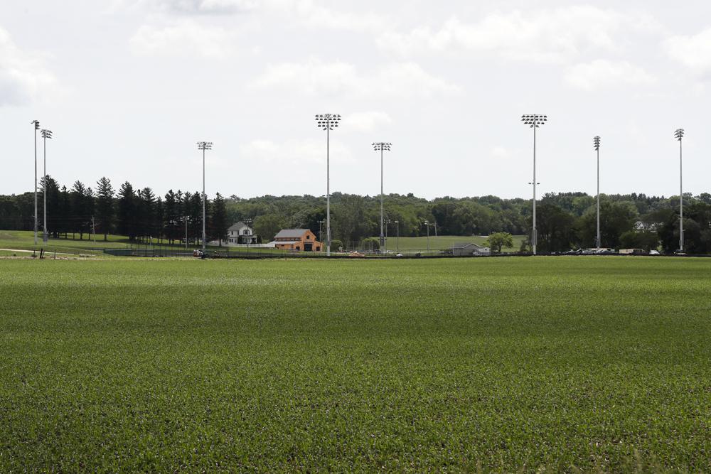 FILE - Light stands from a baseball field being built near the Field of Dreams movie site, rear, are seen in Dyersville, Iowa, in this Friday, June 5, 2020, file photo. Three decades after Kevin Costner's character built a ballpark in a cornfield in the movie "Field of Dreams," the iconic site in Dyersville, Iowa, prepares to host the state's first Major League Baseball game at a built-for-the-moment stadium for the Chicago White Sox and New York Yankees. (AP Photo/Charlie Neibergall, File)