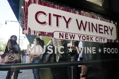 Clientes esperan e  fila para presentar pruebas de vacunación antes de ingresar al City Winery el jueves, 24 de junio del 2021, en la ciudad de Nueva York. Comensales que deseen beber vino, cenar y disfrutar de música en vivo en el restaurant de City Winery en Nueva York deben mostrar prueba de vacunación contra el coronavirus para poder entrar. Pero eso no es requerido ene la mayoría de los otros restaurantes en la ciudad. Ni en los locales de City Winery en el resto de Estados Unidos. (AP Foto/Frank Franklin II)