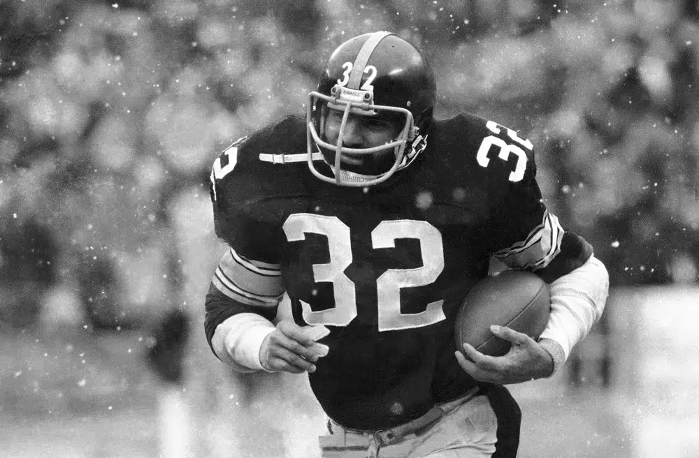 FILE - Franco Harris of the Pittsburgh Steelers runs against the Seattle Seahawks in first period action Sunday, Sept. 10, 1978, in Pittsburgh. Franco Harris, the Hall of Fame running back whose heads-up thinking authored “The Immaculate Reception,” considered the most iconic play in NFL history, died Wednesday, Dec. 21, 2022. He was 72. (AP Photo/RCG)