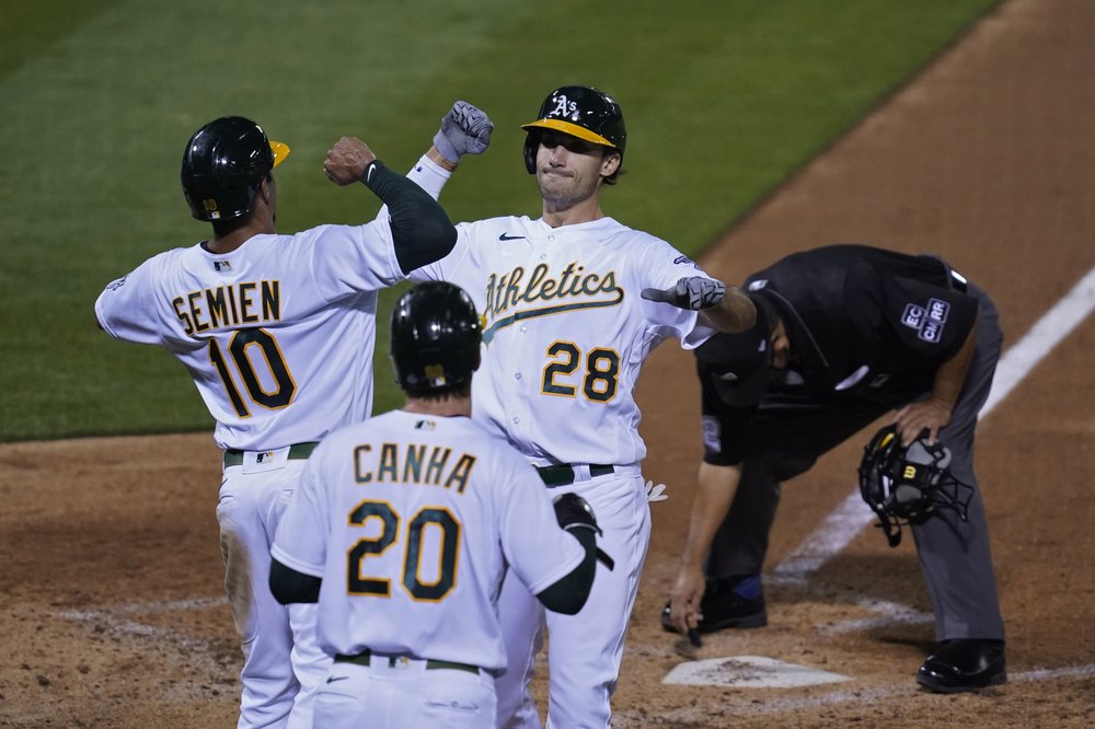 Matt Olson (28), de Oakland Athletics, es recibido por Marcus Semien (10) y Mark Canha (20) después de conectar un jonrón de tres carreras al abridor de los Gigantes de San Francisco, Logan Webb, durante la tercera entrada de un juego de béisbol el viernes, sept. 18 de febrero de 2020 en Oakland, California.