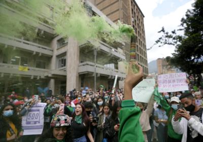 Un activista por el derecho al aborto sostiene una bengala frente a la Corte Constitucional mientras los jueces continúan las discusiones sobre la despenalización del aborto en Bogotá, Colombia, el jueves 3 de febrero de 2022. (AP Foto/Fernando Vergara)