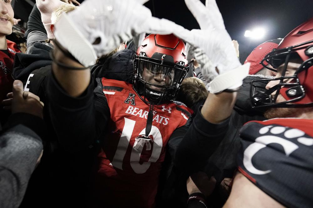 Cincinnati's Bryon Threats (10) celebrates after defeating Houston in the American Athletic Conference championship NCAA college football game Saturday, Dec. 4, 2021, in Cincinnati. (AP Photo/Jeff Dean)