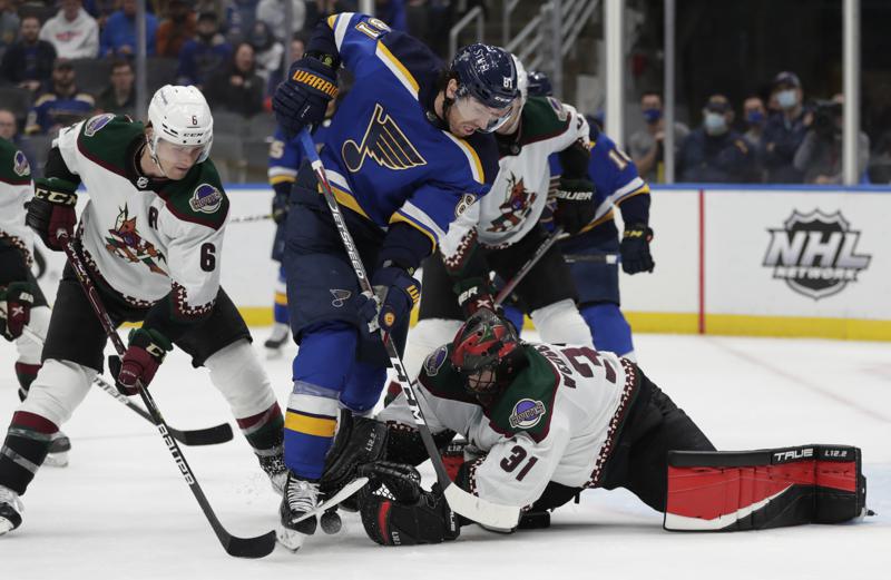 Arizona Coyotes goaltender Scott Wedgewood dives for the puck as St. Louis Blues' James Neal (81) tries to poke it free, while Coyotes' Jakob Chychrun (6) helps defend during the second period of an NHL hockey game Tuesday, Nov. 16, 2021 in St. Louis. (AP Photo/Tom Gannam)