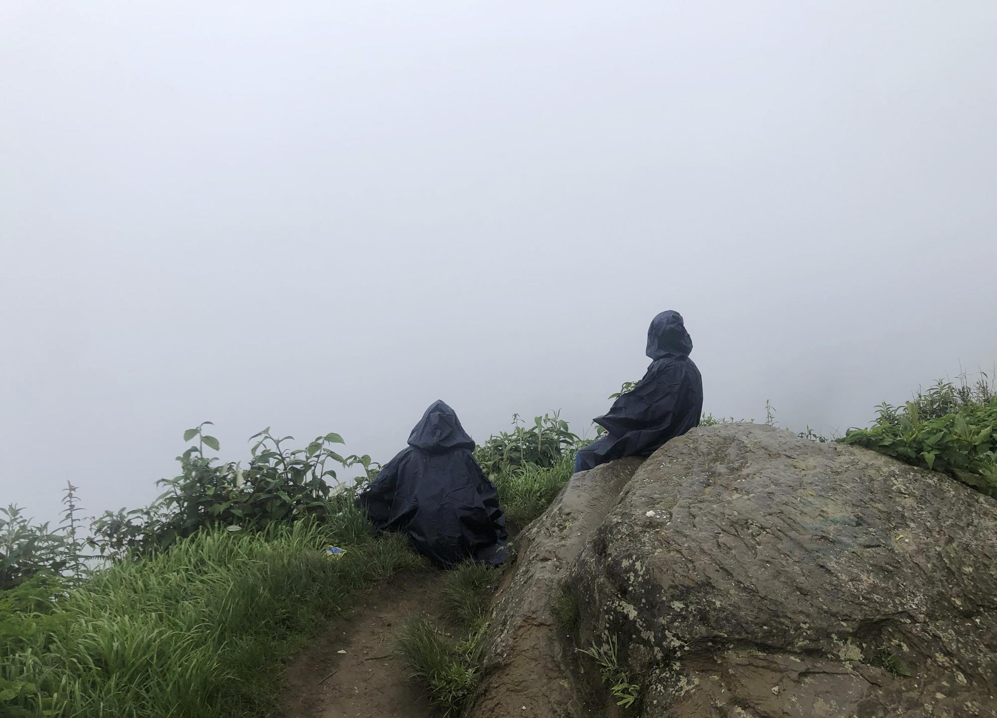 Una madre y su hija miran hacia las nubes en la cumbre cerca del valle de Dzukou, a lo largo de la frontera estatal de Nagaland-Manipur, India, en esta foto de iPhone del lunes 13 de junio de 2022.  "Fue un momento tranquilo al final de una subida lluviosa y resbaladiza. Ambos estaban paralizados, absortos en la soledad de las nubes. Sabía que en un momento se les unirían más personas, así que rápidamente levanté mi teléfono y tomé este marco", escribió Arthur.  (Foto AP/Yirmiyan Arthur)