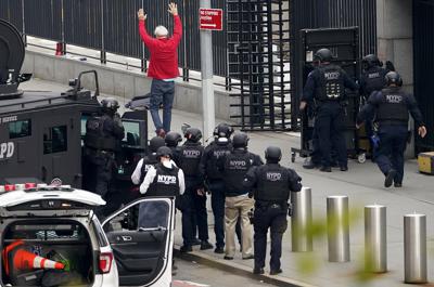 Un hombre que había estado merodeando afuera de la sede de las Naciones Unidas con un arma se entrega a la policía de Nueva York el jueves 2 de diciembre de 2021, en Nueva York. (AP Foto/John Minchillo)