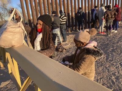 ARCHIVO - Una mujer cubana y su hija aguardan en una fila para que las lleven hasta una camioneta de la Patrulla Fronteriza con el fin de que les procesen su solicitud de admisión, en Yuma, Arizona, el 6 de febrero de 2022, con la esperanza de que les permitan permanecer en Estados Unidos a fin de solicitar asilo. (AP Foto/Elliot Spagat, archivo)