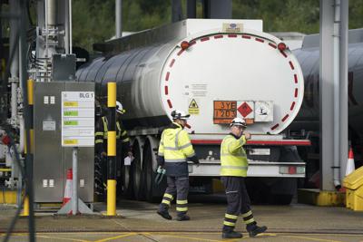 Trabajadores del depósito de gasolina de Buncefield, conocida como Terminal de Almacenamiento de Hertfordshire, en Hemel Hempstead, Inglaterra, el lunes 4 de octubre de 2021. Personal militar británico empezó el lunes a repartir combustible a las estaciones de servicio, después de que la falta de camioneros afectara al suministro durante más de una semana, lo que provocó largas filas en las gasolineras mientras conductores ansiosos trataban de llenar sus depósitos.  (Joe Giddens/PA via AP)
