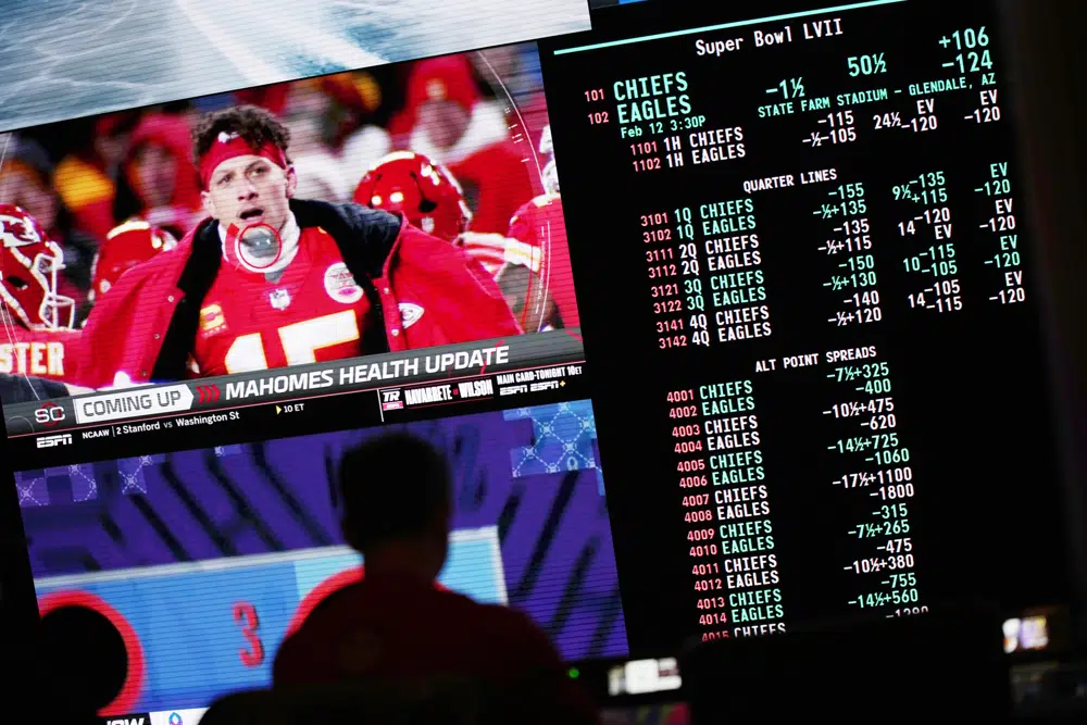 A person gambles as betting odds for NFL football's Super Bowl are displayed on monitors at the Circa resort and casino sports book Friday, Feb. 3, 2023, in Las Vegas. (AP Photo/John Locher)