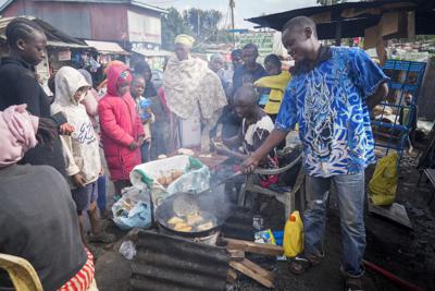 Un hombre utiliza aceite de cocina para freír mandazi, una clase de pan frito, en una calle en el vecindario humilde de Kibera, en Nairobi, Kenia, el miércoles 20 de abril de 2022. (AP Foto/Khalil Senosi)