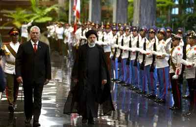 El presidente de Cuba, Miguel Díaz-Canel, a la izquierda, y el presidente de Irán, Ebrahim Raisi, caminan frente a la guardia de honor durante su visita a La Habana, Cuba, el jueves 15 de junio de 2023. (AP Foto/Ismael Francisco)