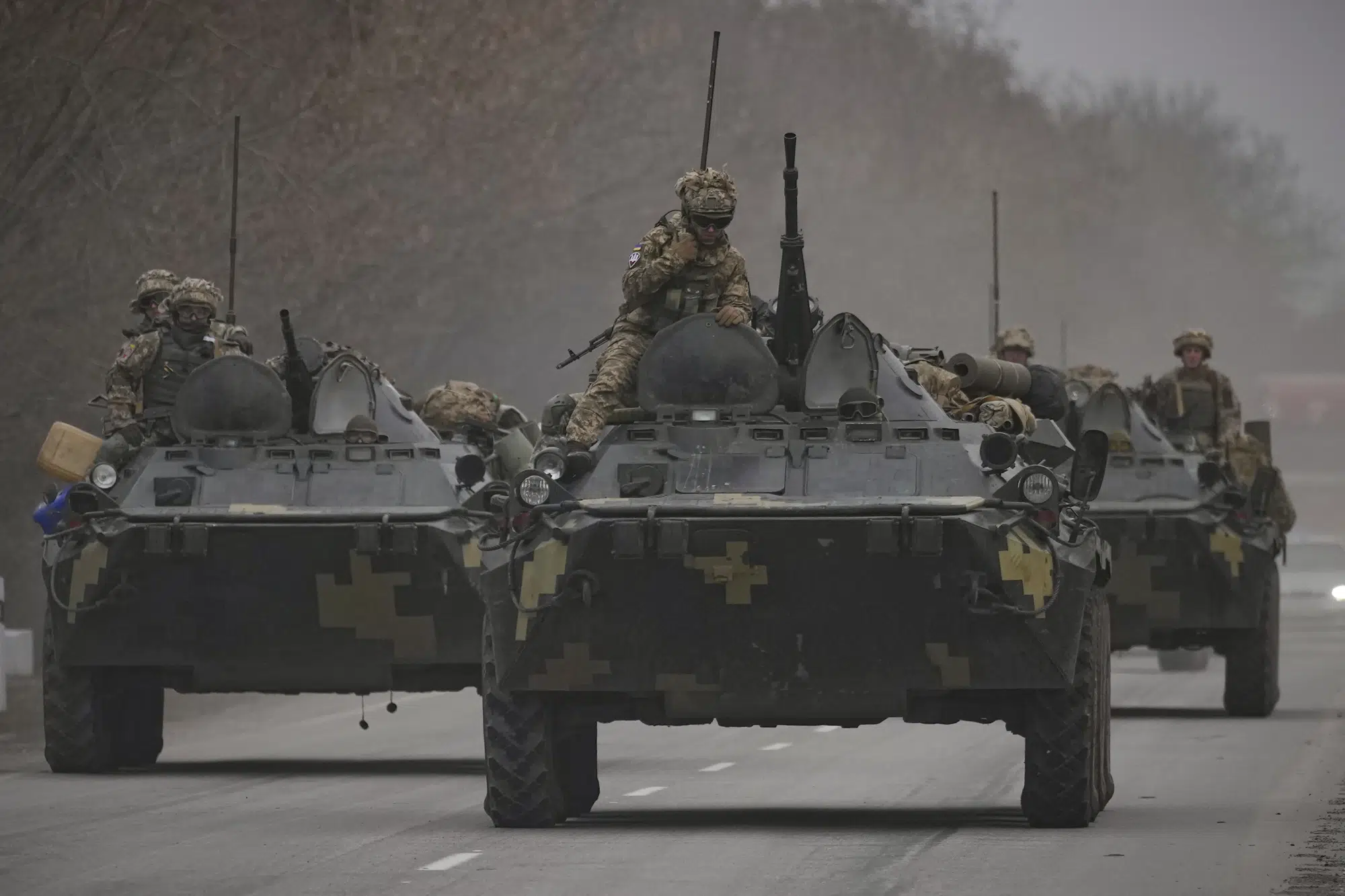 FILE - Ukrainian servicemen sit atop armored personnel carriers driving on a road in the Donetsk region, eastern Ukraine, Thursday, Feb. 24, 2022. (AP Photo/Vadim Ghirda, File)